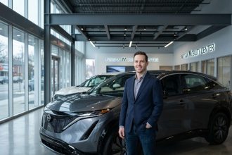 Un homme en blazer marine admire un SUV Nissan dans une concession automobile moderne aux sols en béton poli