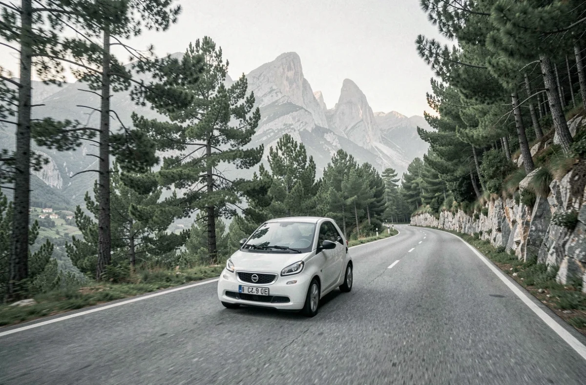 Voiture sans permis circulant sur une route de montagne sinueuse en Corse entourée de forêts et de sommets granitiques